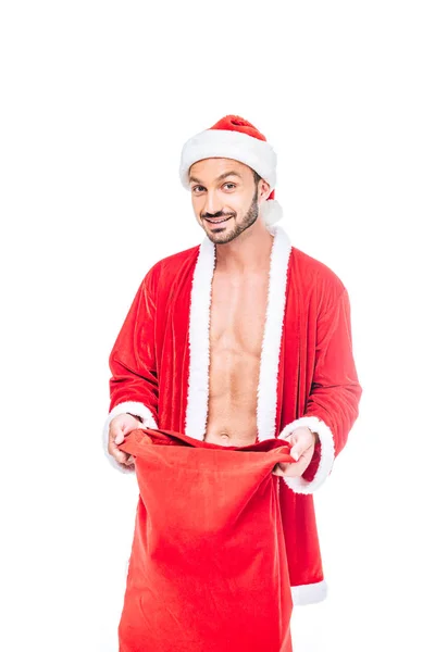 Sorridente muscular homem em santa claus traje com natal saco isolado no fundo branco — Fotografia de Stock