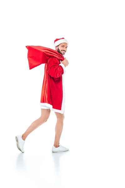 Young man in santa claus costume with christmas sack isolated on white background — Stock Photo
