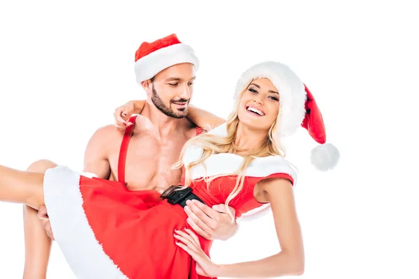 Young muscular shirtless man in christmas hat holding happy girlfriend on hands isolated on white background — Stock Photo