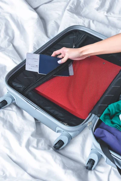 Cropped shot of woman packing luggage for trip on bed — Stock Photo