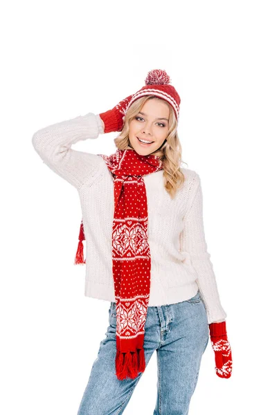 Привлекательная молодая женщина в красной шляпе, шарфе и варежках, улыбающаяся в камеру, изолированную на белом — стоковое фото