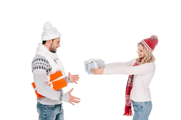 Vista laterale di felice giovane coppia che presenta scatole regalo isolate su bianco — Foto stock