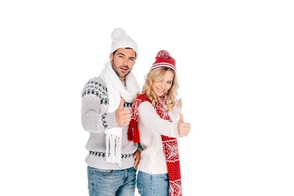 Hermosa pareja joven en traje de invierno mostrando los pulgares hacia arriba y sonriendo a la cámara aislada en blanco - foto de stock