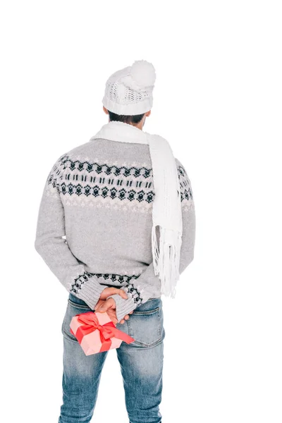 Back view of man in sweater, scarf and hat holding gift box isolated on white — Stock Photo