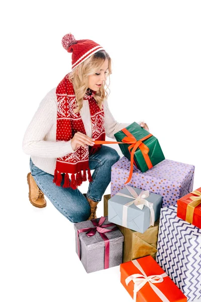 Приваблива дівчина в шарфі і капелюсі відкриває подарункову коробку ізольовано на білому — стокове фото