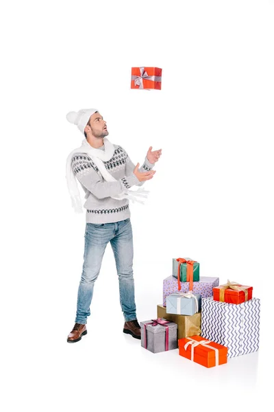 Bel homme en écharpe et chapeau jetant boîte cadeau et regardant isolé sur blanc — Photo de stock