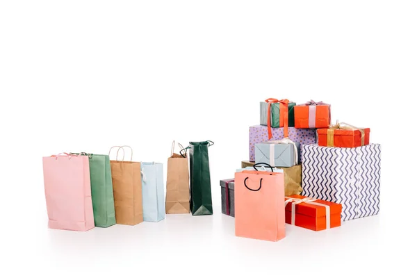 Coloridas bolsas de compras y varias cajas de regalo apiladas aisladas en blanco - foto de stock
