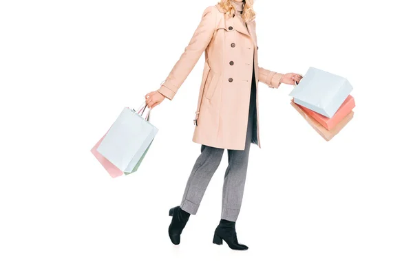 Plan recadré de jeune femme tenant des sacs en papier et marchant isolé sur blanc — Photo de stock