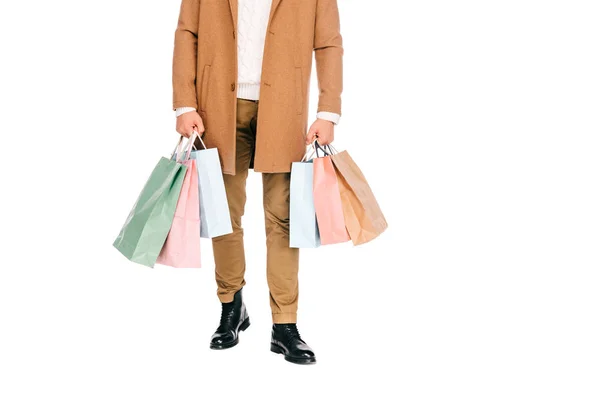 Section basse de jeune homme tenant des sacs en papier isolés sur blanc — Photo de stock