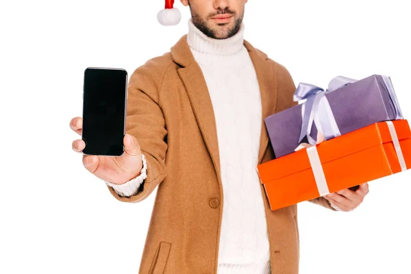 Cropped shot of man in santa hat holding gift boxes and smartphone with blank screen isolated on white — Stock Photo