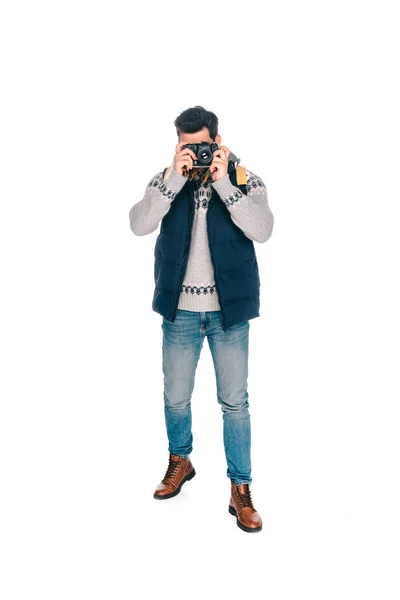 Вигляд на повну довжину молодого чоловіка з рюкзаком фотографування з камерою ізольовано на білому — стокове фото