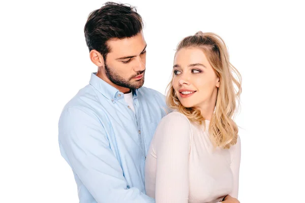 Belo jovem casal abraçando e sorrindo uns aos outros isolado no branco — Fotografia de Stock