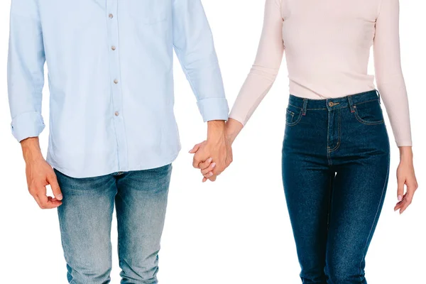 Обрезанный снимок молодой пары, держащейся за руки изолированные на белом — стоковое фото