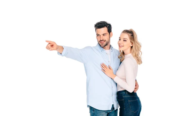 Sonriente joven pareja de pie juntos y mirando hacia otro lado aislado en blanco - foto de stock