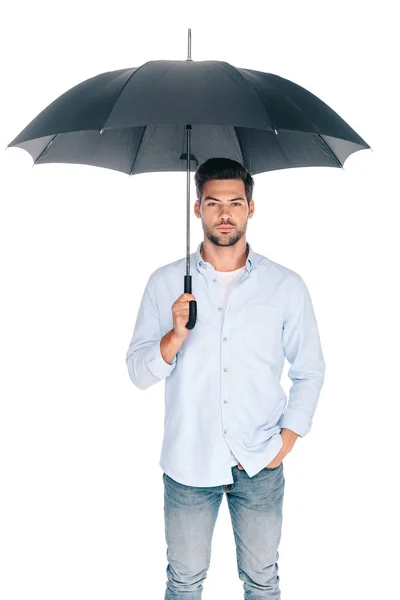 Bello barbuto giovane uomo che tiene l'ombrello e guardando la fotocamera isolata su bianco — Foto stock