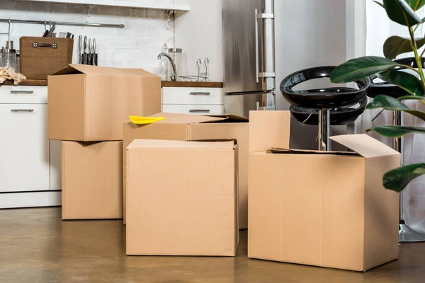 Interior of modern kitchen with cardboard boxes during relocation at new home — Stock Photo