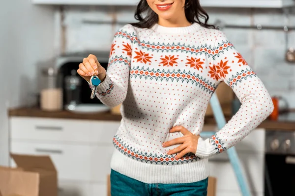 Vista parcial de la mujer joven mostrando las llaves en la cocina en el nuevo hogar - foto de stock