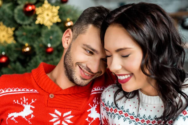 Selective focus of smiling young couple near decorated christmas tree at home — Stock Photo