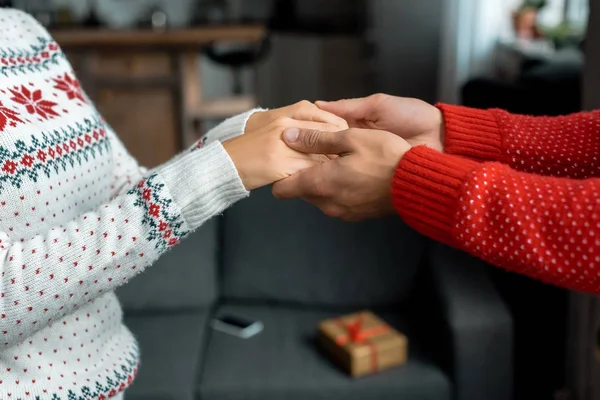 Abgeschnittenes Bild eines Mannes, der Händchen hält und Freundin führt, um an Weihnachten zu Hause eine Überraschung zu machen — Stockfoto
