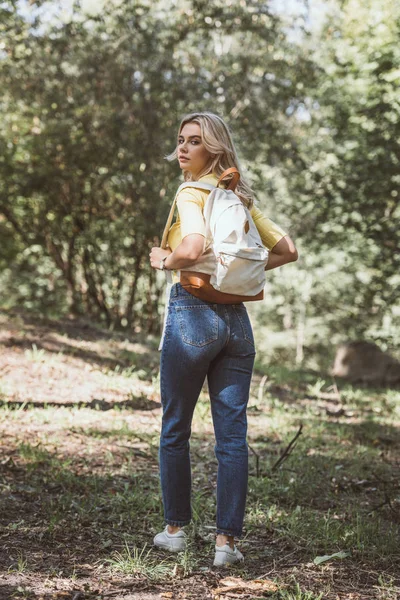 Rear view of beautiful young woman with backpack in park — Stock Photo