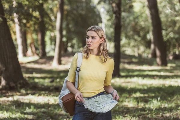 Portrait de jeune touriste avec sac à dos et carte dans le parc — Photo de stock