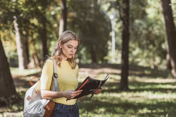 Portrait of young tourist with backpack and map in park — Stock Photo