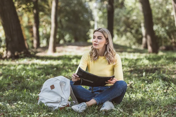 Jeune touriste avec carte reposant dans le parc — Photo de stock