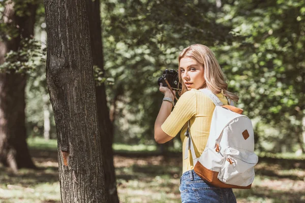 Rückansicht eines Touristen beim Fotografieren mit Fotokamera im Park — Stockfoto