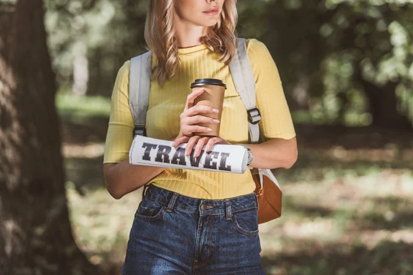Обрізаний знімок жінки з кавою, щоб піти і подорожувати газетою в парку — стокове фото