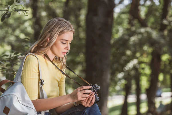 Vista laterale del giovane turista con macchina fotografica nel parco — Foto stock