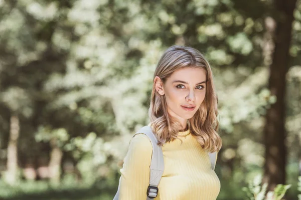 Retrato de hermosa joven con mochila en el parque - foto de stock