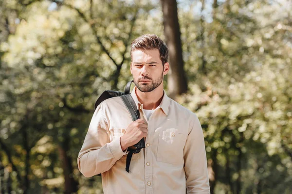 Nachdenklicher junger Mann mit Rucksack im Herbstpark — Stockfoto