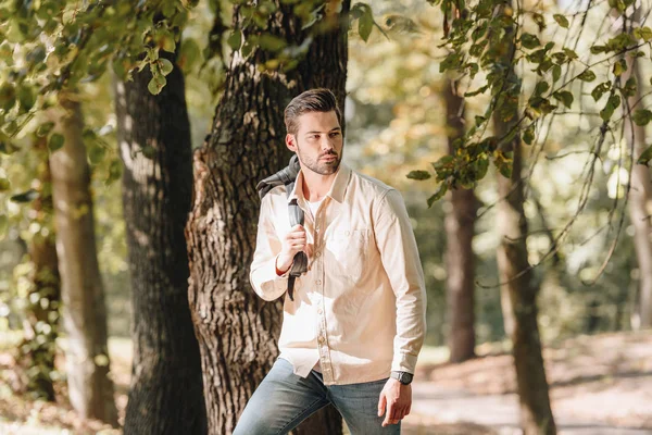 Портрет стильного молодого чоловіка з рюкзаком в осінньому парку — стокове фото