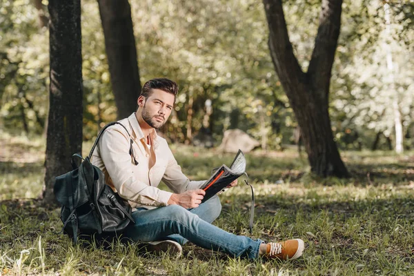 Side view of pensive traveler with map and backpack in park — Stock Photo