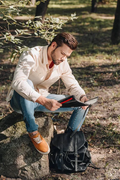 Young traveler looking for destination on map in park — Stock Photo