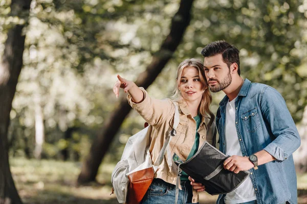Portrait of couple of tourists with map in park — Stock Photo