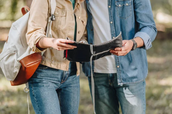 Partial view of couple of tourists holding map in hands in park — Stock Photo