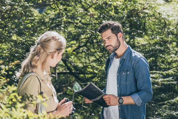 Pareja de viajeros con mapa y cámara fotográfica en el parque - foto de stock