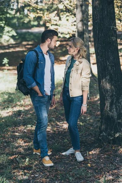 Молодая стильная пара смотрит друг на друга в осеннем парке — стоковое фото