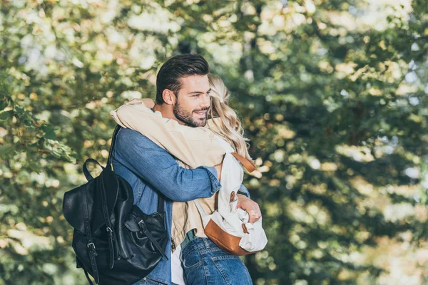 Vista lateral de pareja romántica abrazándose en el parque de otoño - foto de stock