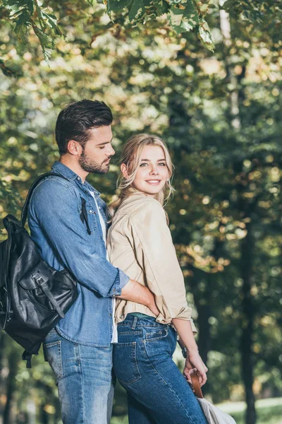 Vue latérale du couple romantique debout dans le parc d'automne — Photo de stock