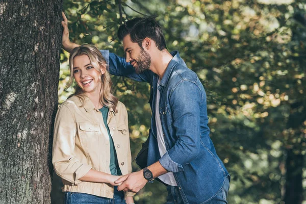 Feliz pareja romántica cogida de la mano en otoño parque - foto de stock
