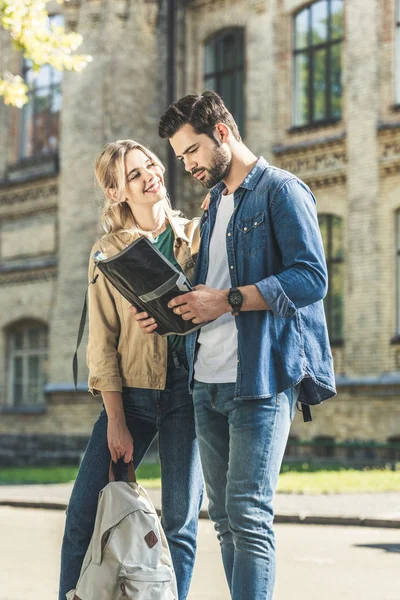 Young tourists with map on street — Stock Photo