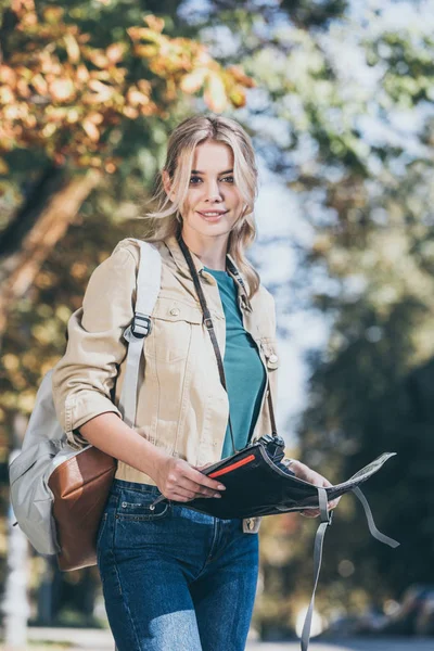 Portrait de jeune voyageur avec sac à dos, appareil photo et carte sur la rue — Photo de stock