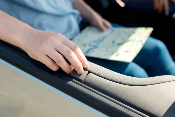 Cropped shot of woman holding travel map inside car — Stock Photo