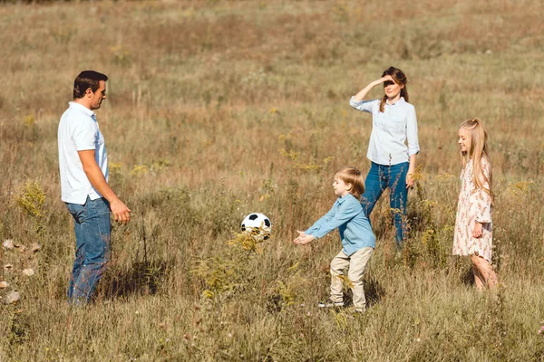 Красива молода сім'я грає у футбол разом у природі — стокове фото