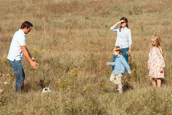 Heureux jeune famille jouer au football ensemble dans la nature — Photo de stock