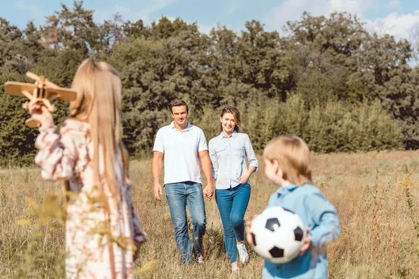 Feliz familia joven pasar tiempo juntos en la naturaleza - foto de stock