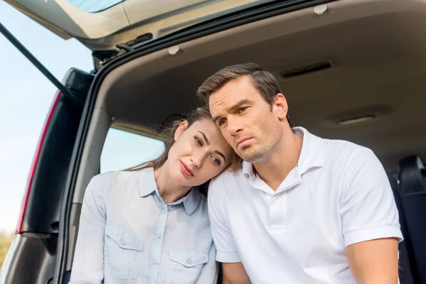 Sad adult couple sitting in car together and looking away — Stock Photo