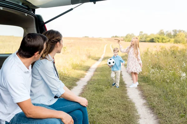 Jeune famille passer du temps ensemble sur le terrain tout en voyageant en voiture — Photo de stock